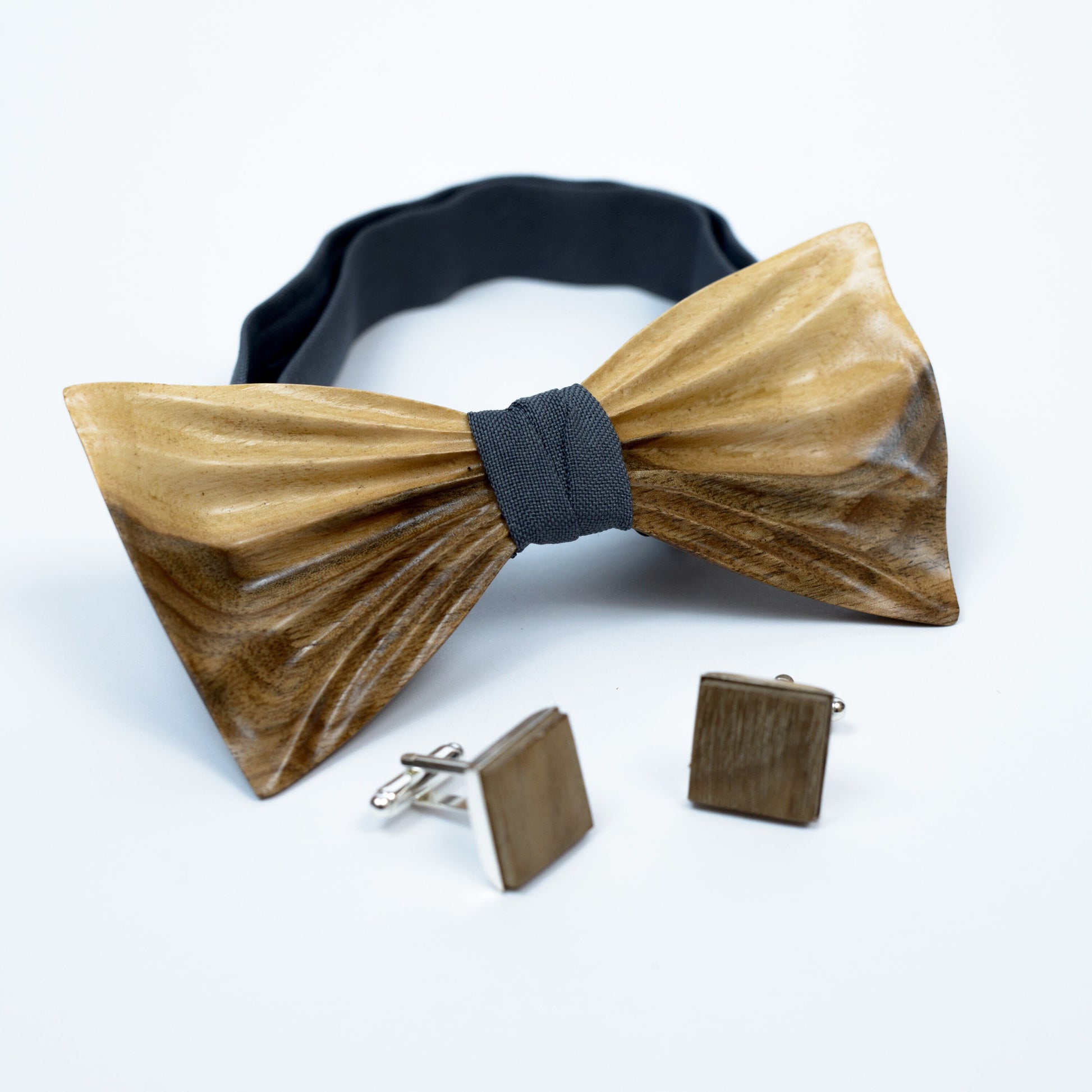 Wedding accessories set featuring a wooden bow tie, matching pocket square, and monogram cufflinks.