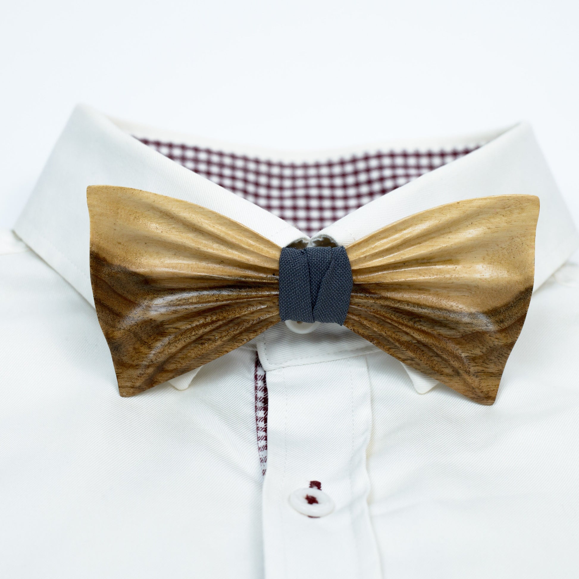 A stylish wooden bowtie for men, paired with a neatly folded pocket square in a rich fabric color.