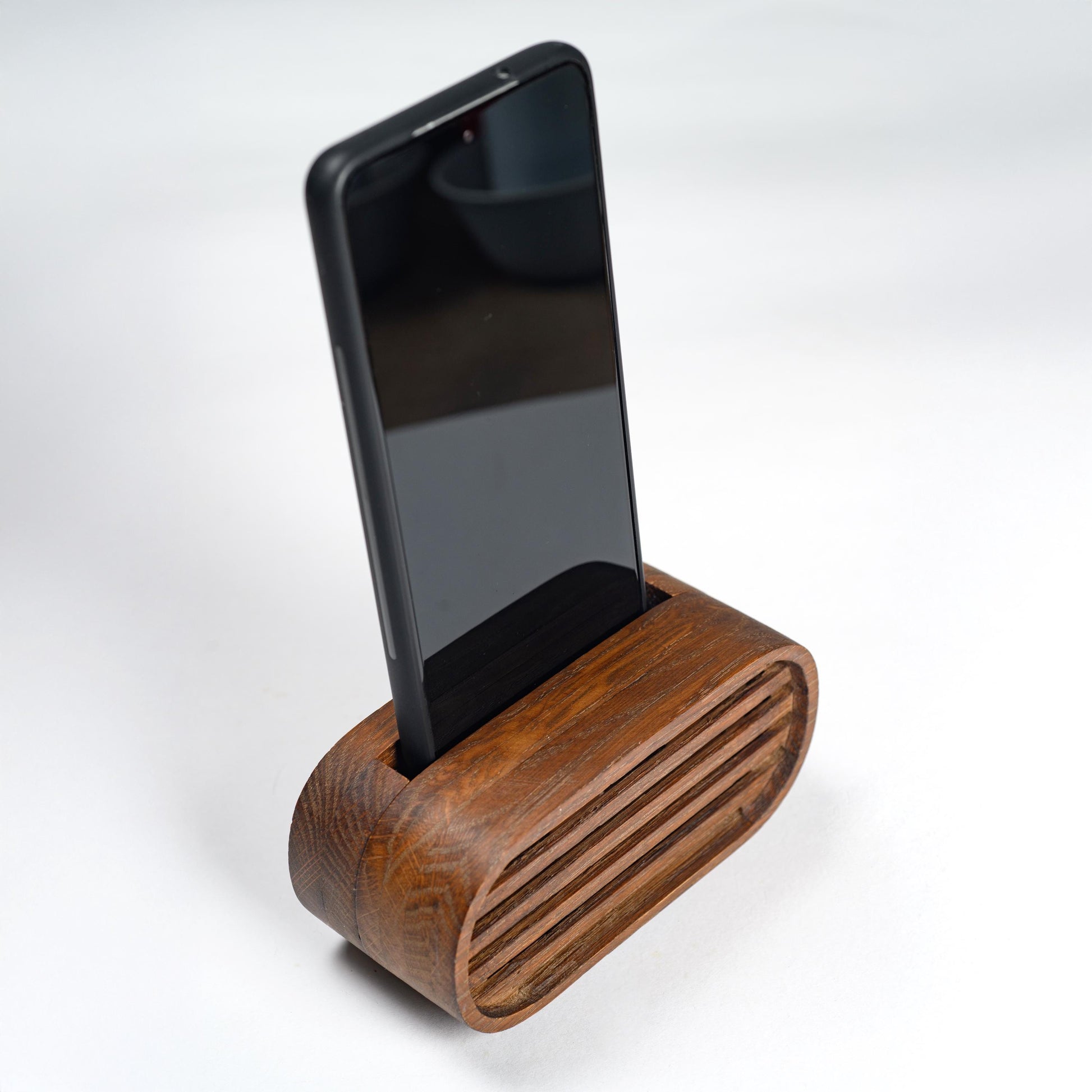 Oak wood phone stand with passive amplifier, boosts sound naturally, fits iPhone and Android.