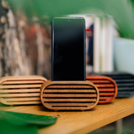 Rustic wooden phone speaker in home office, eco-friendly sound amplifier for music lovers.
