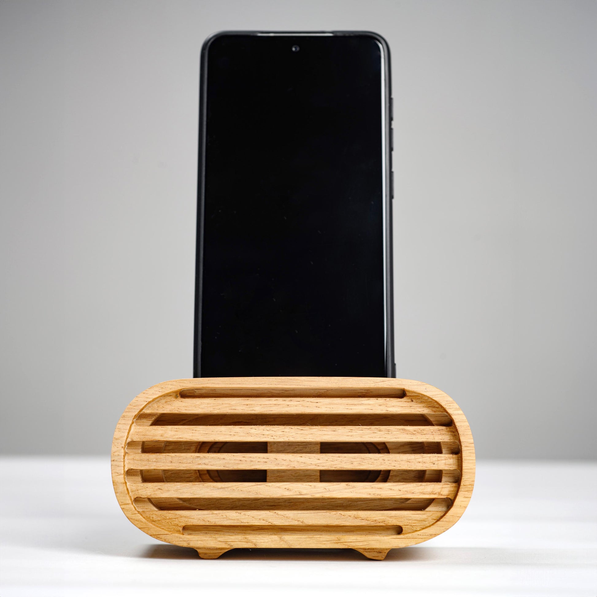 Oak wood phone stand with passive amplifier, boosts sound naturally, fits iPhone and Android.