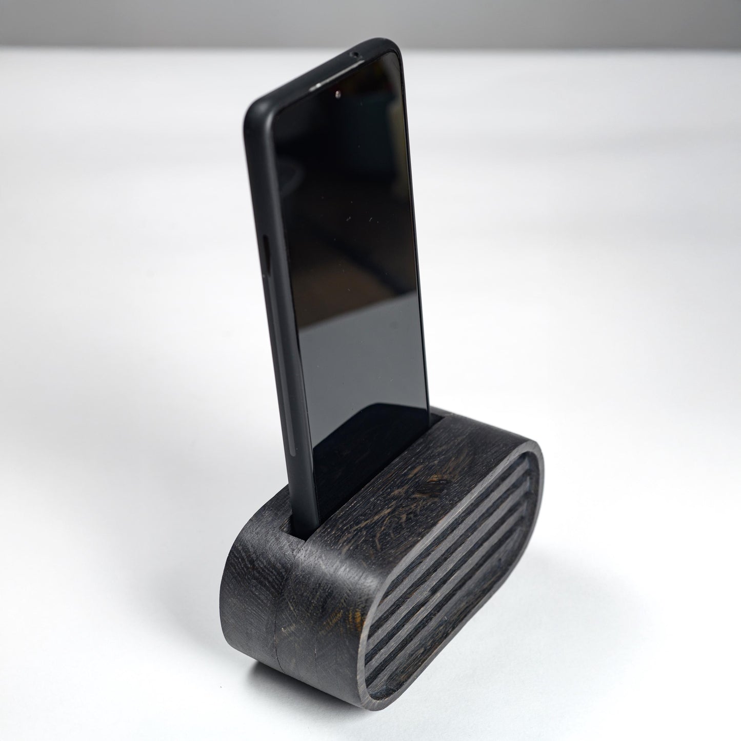 Oak wood phone stand with passive amplifier, boosts sound naturally, fits iPhone and Android.