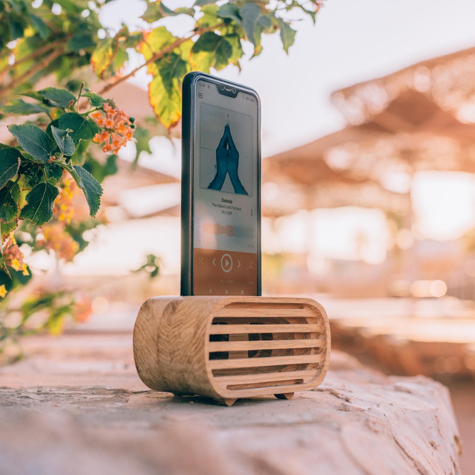 Rustic wooden phone speaker in home office, eco-friendly sound amplifier for music lovers.