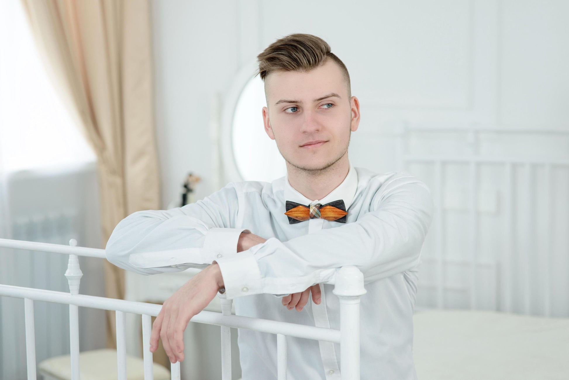 Man wearing a classic wooden bow tie, a unique fashion statement for weddings and formal events.