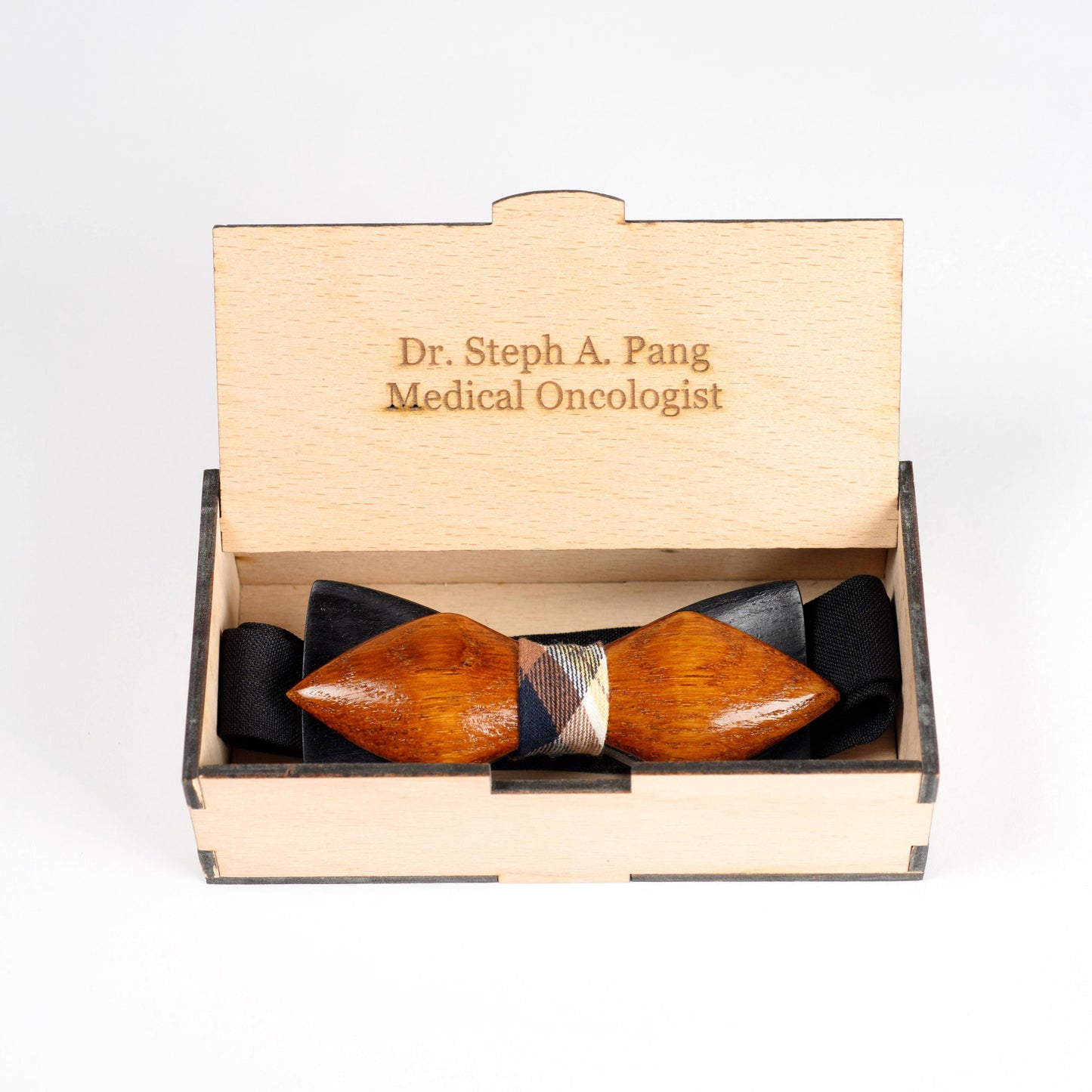 Open wooden gift box showcasing a handmade wooden bow tie with personalized engraving.