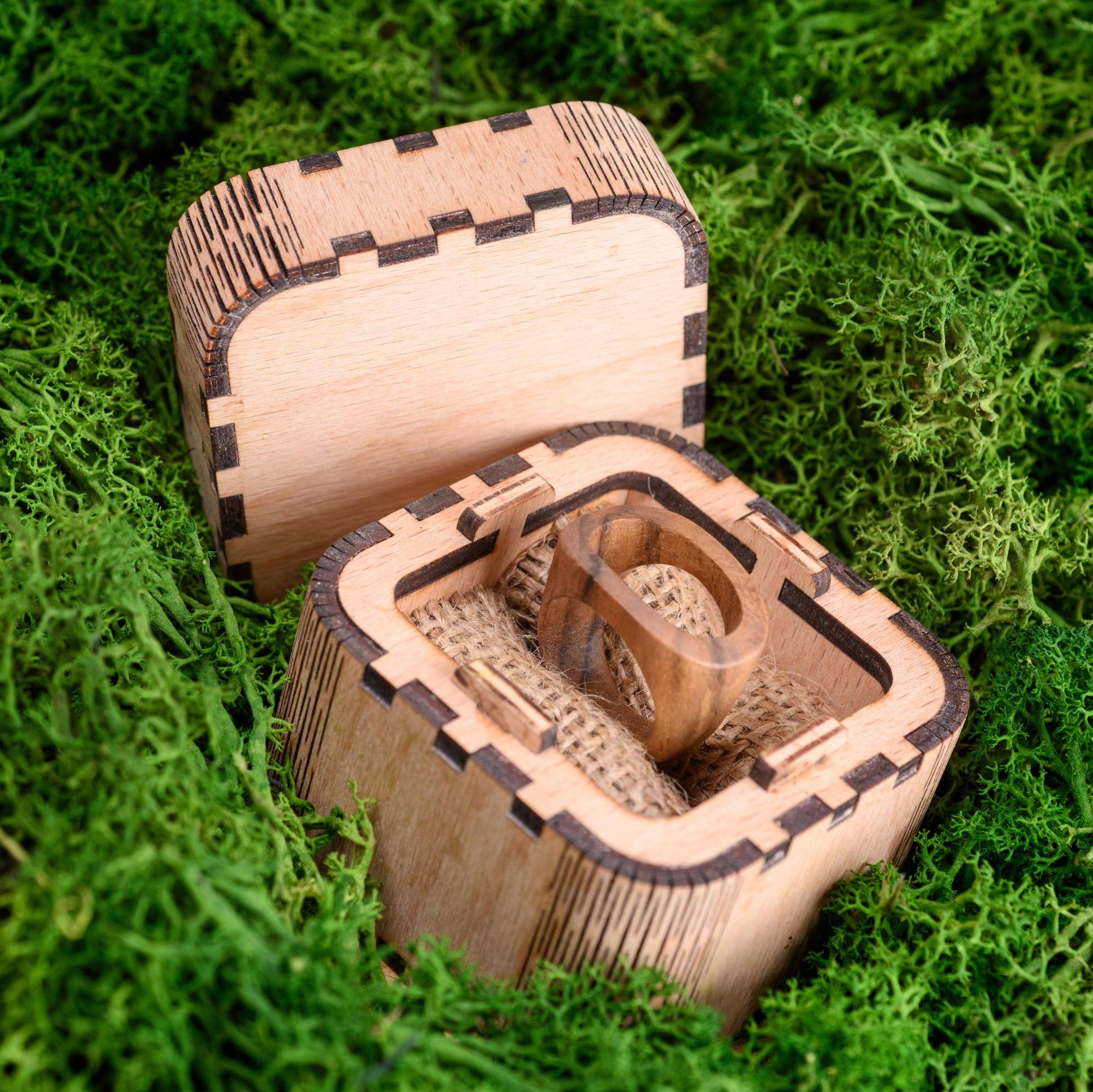 Wooden men's wedding ring displayed in a personalized wooden gift box.
