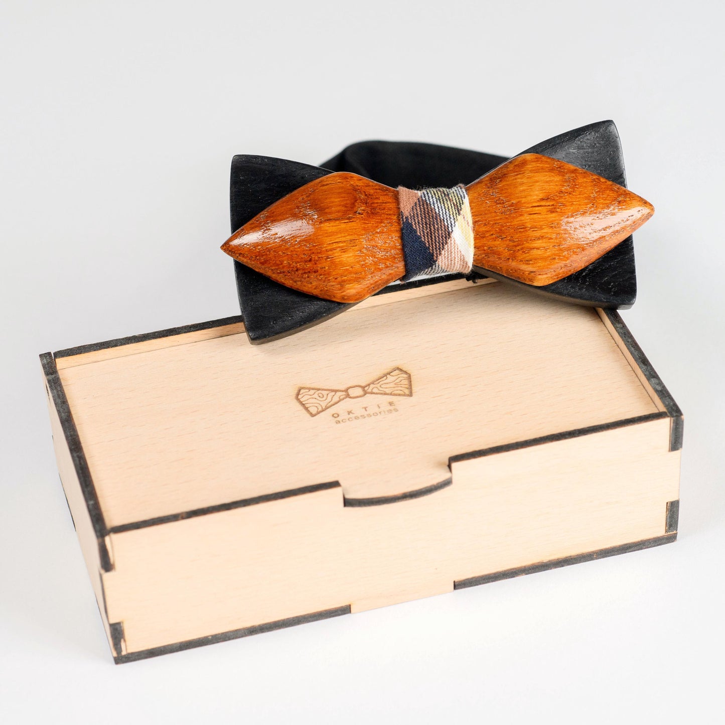 Angled view of a handcrafted oak wood bow tie, highlighting its smooth finish and design.