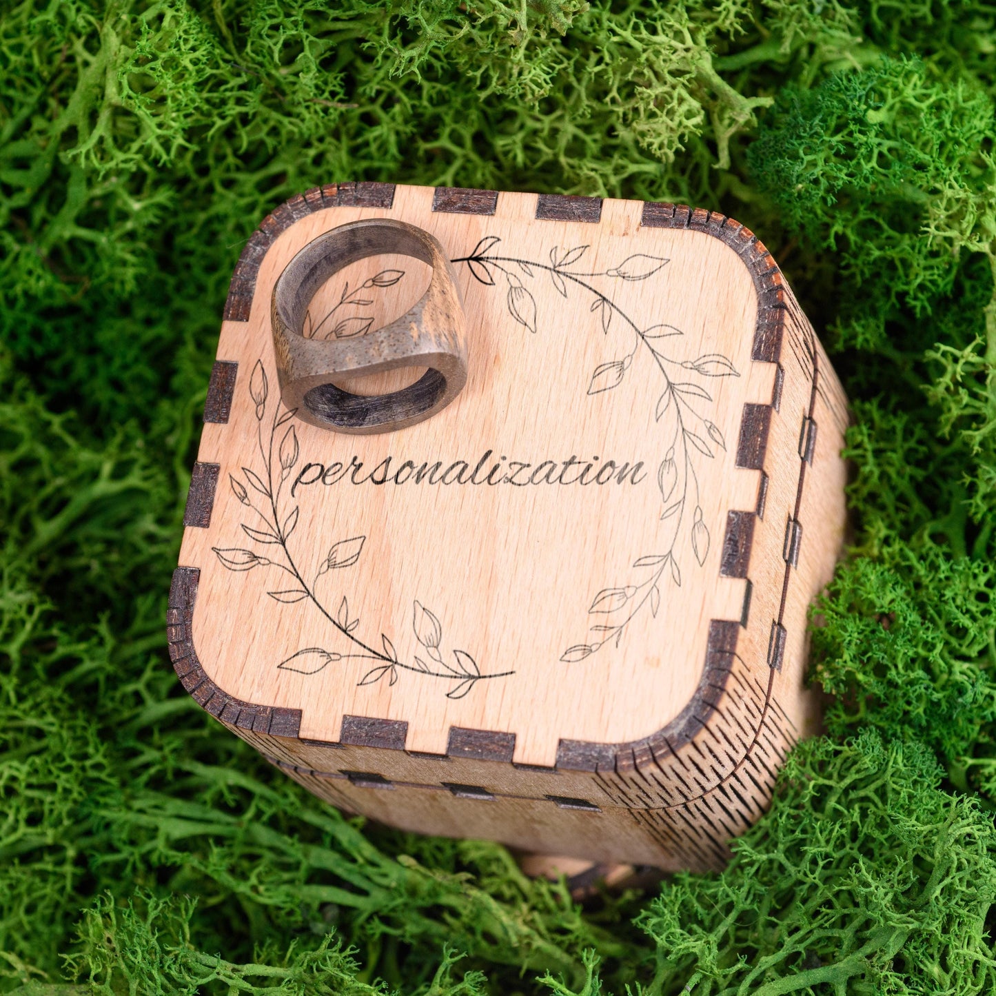 Wooden men's wedding ring displayed in a personalized wooden gift box.